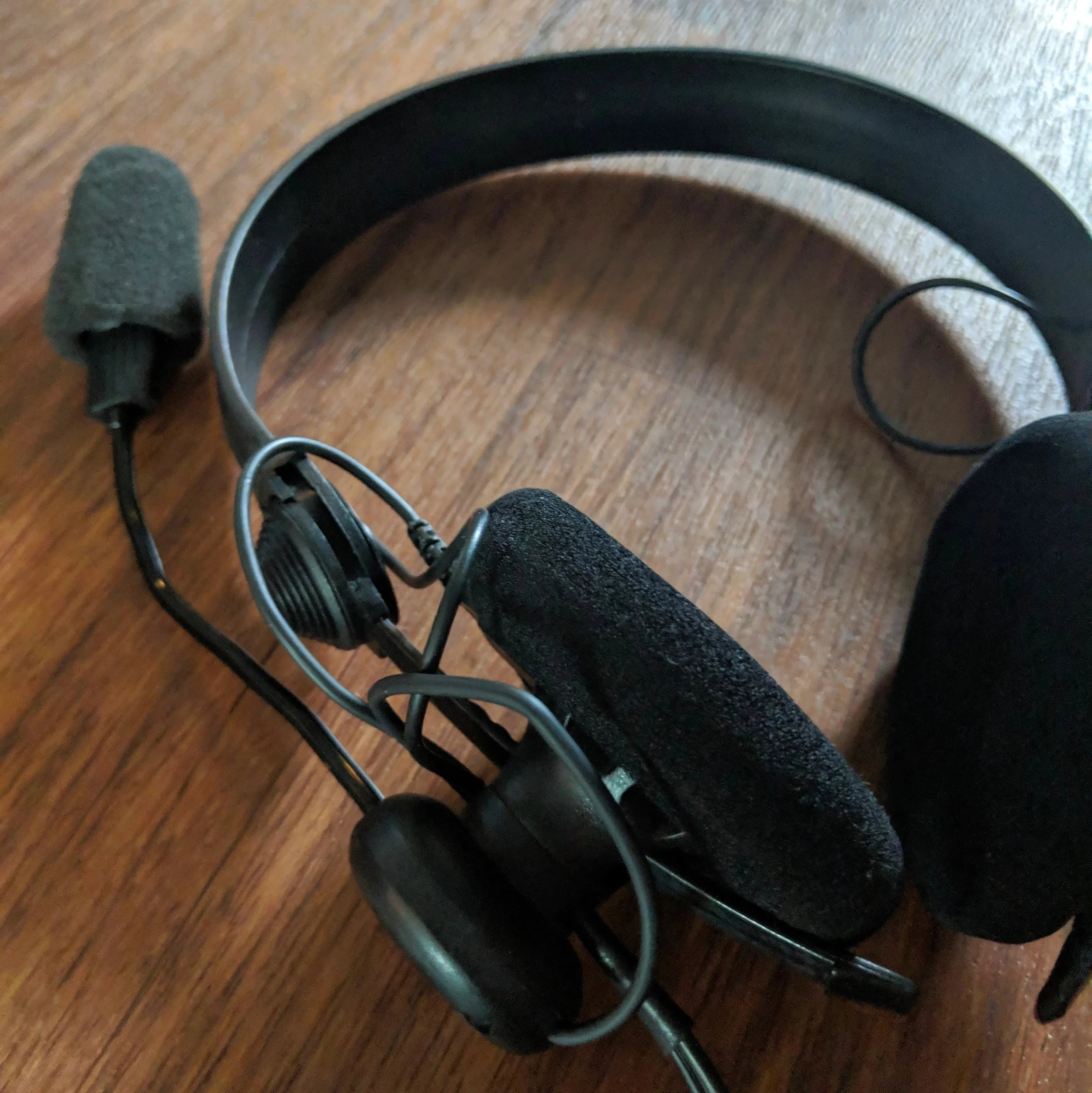 Nahaufnahme eines professionellen Headsets für Simultandolmetscher auf einer Holzoberfläche.