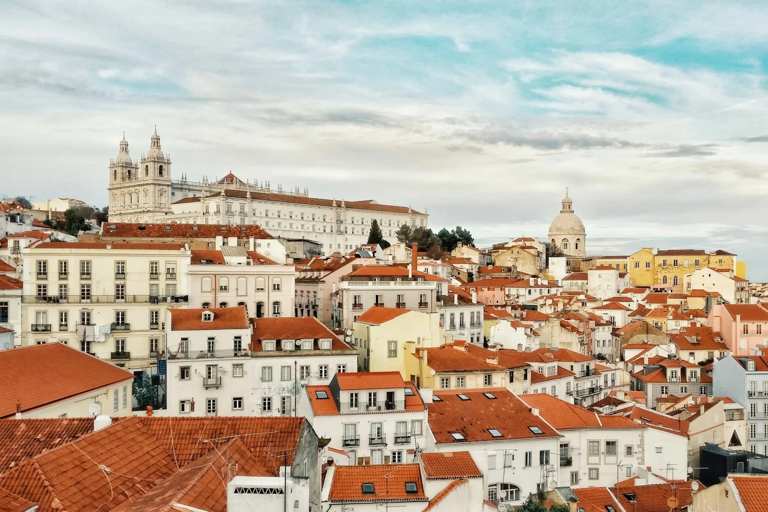 Blick über die roten Dächer von Lissabon als Symbolbild für Dolmetsch-Dienstleistungen in der Sprachkombination Portugiesisch und Deutsch.
