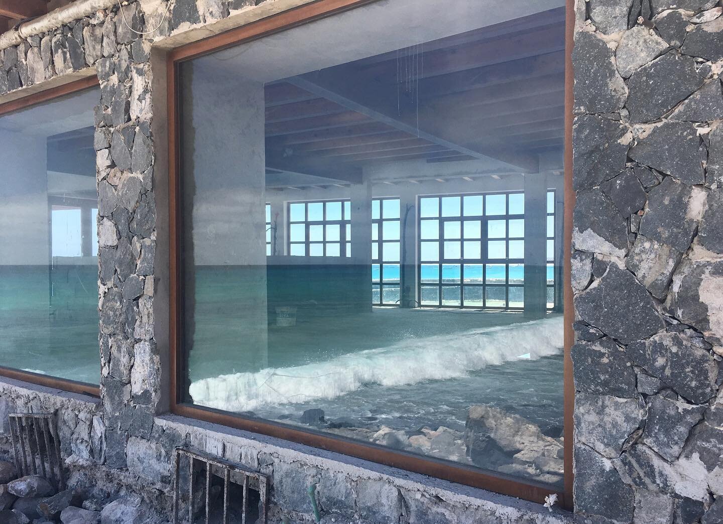 Photo of the left window taken from the outside of the restaurant, with the reflection of the beach.