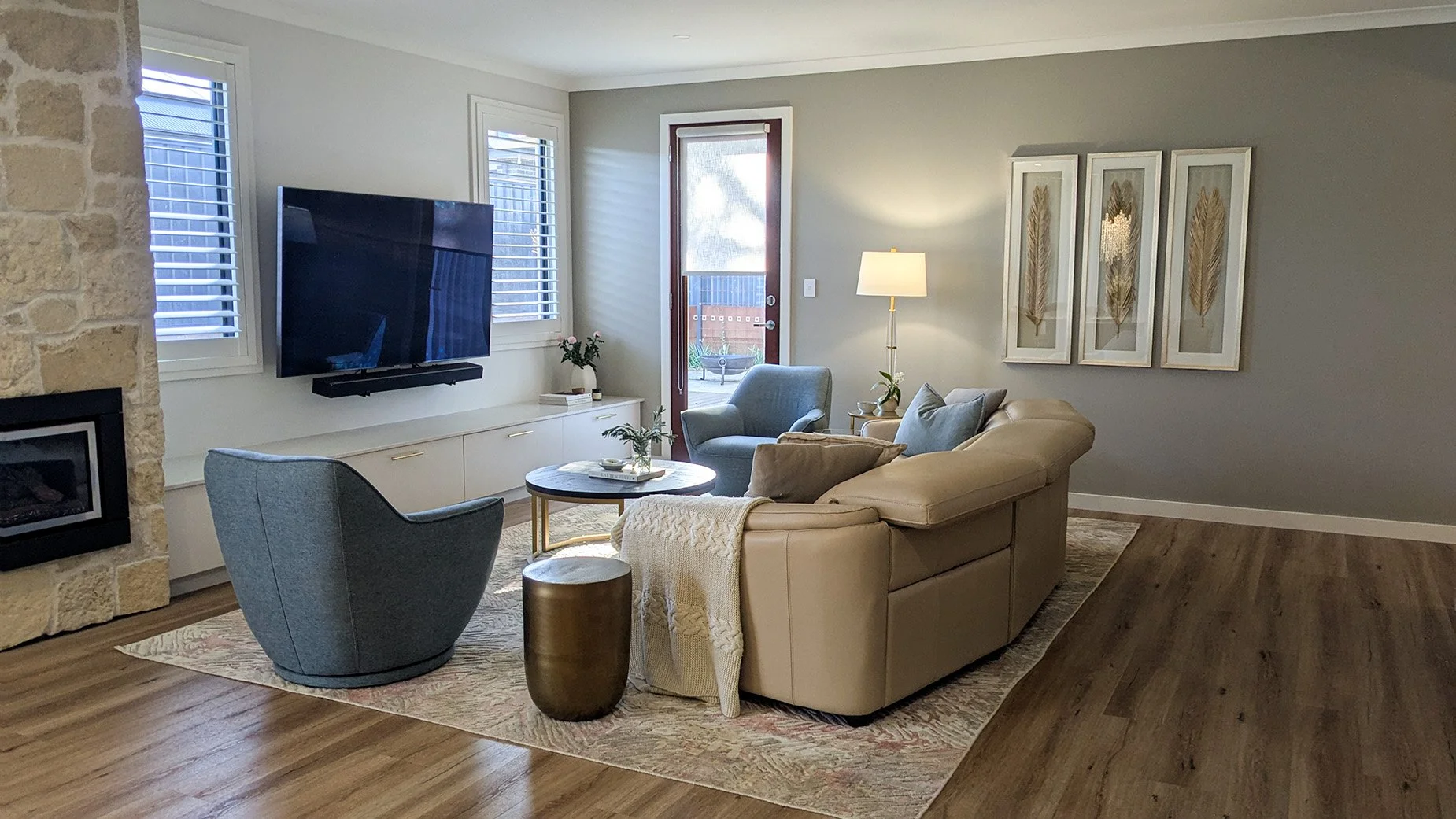 Lounge room with blue occasional chair, patterned rug and leather sofa