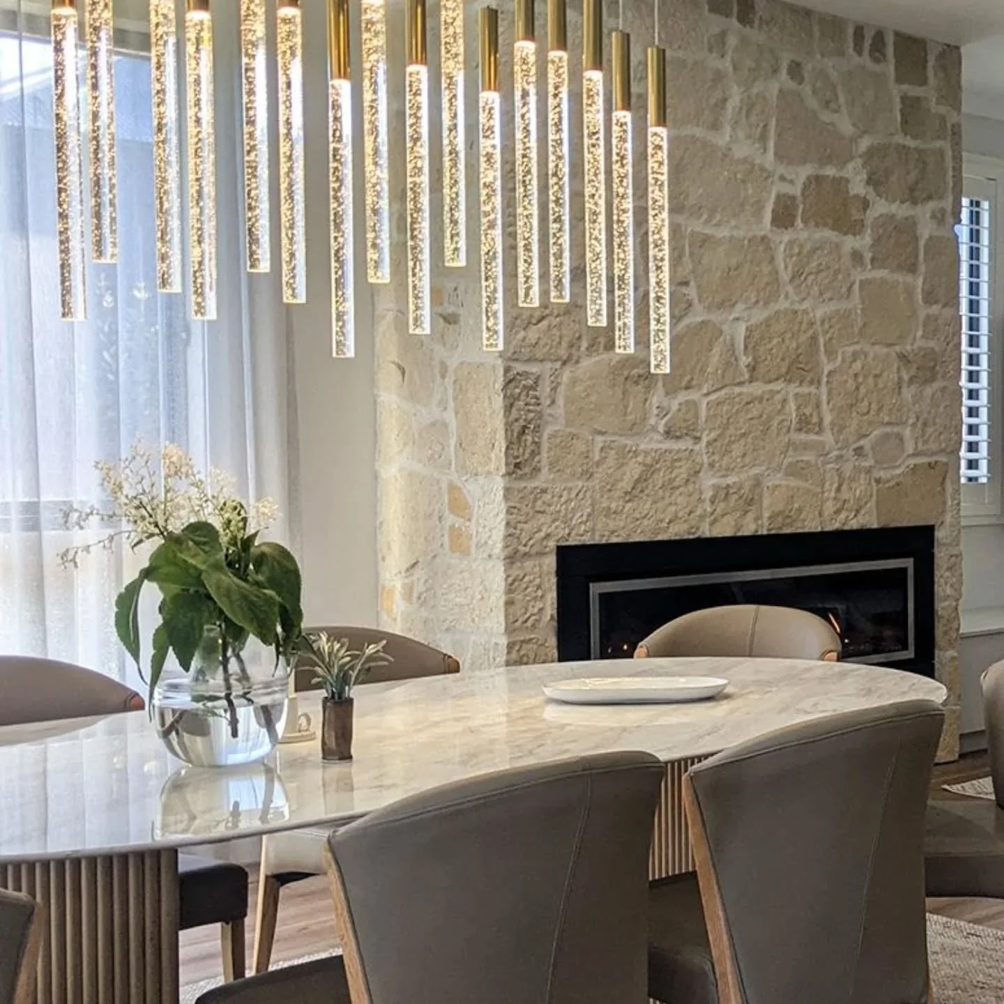 Texture is everything&mdash;especially when you want a space to feel both sophisticated and inviting.⁠
⁠
In this dining room, I layered natural stone, rich timber, smooth marble, soft leather, sheer curtains, and a striking glass + brass pendant to b