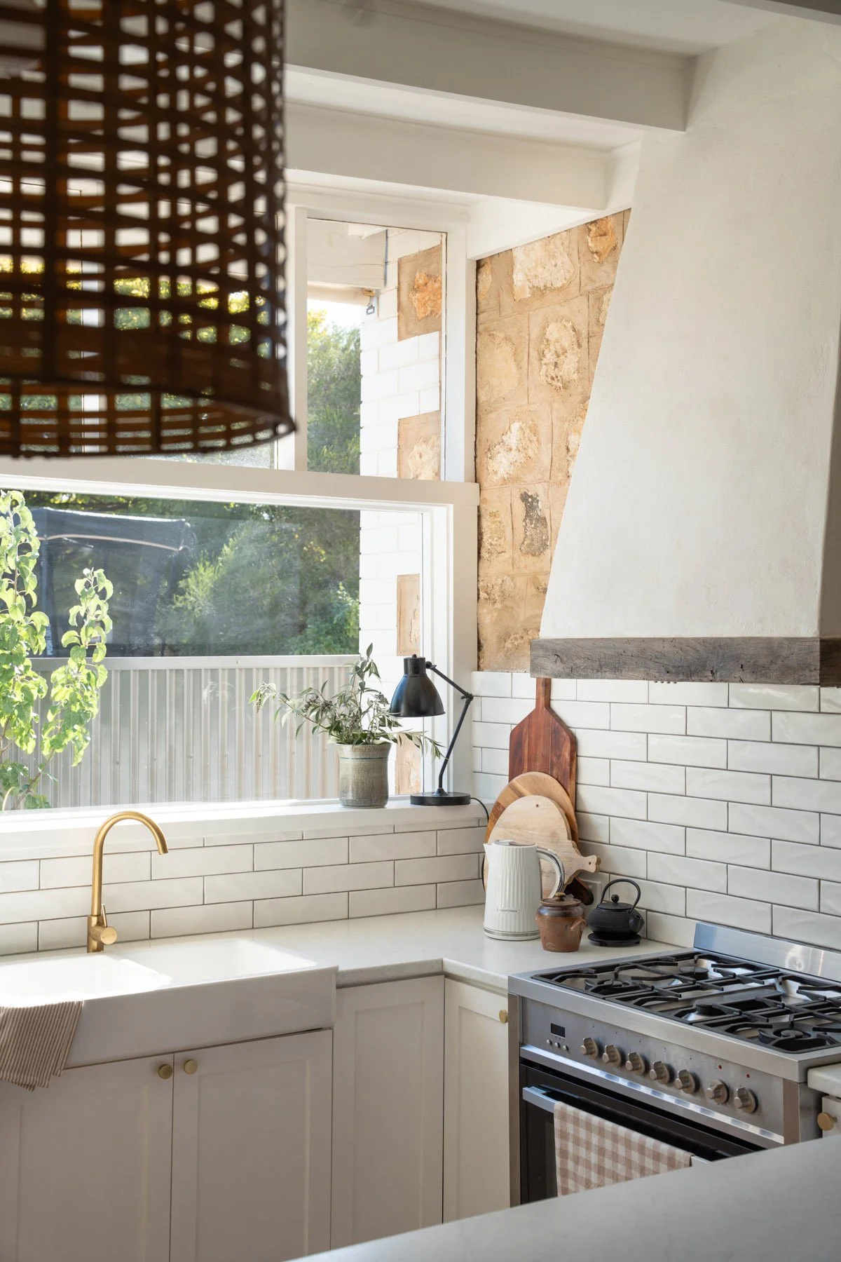 Country kitchen with custom range hood and farmhouse sink.