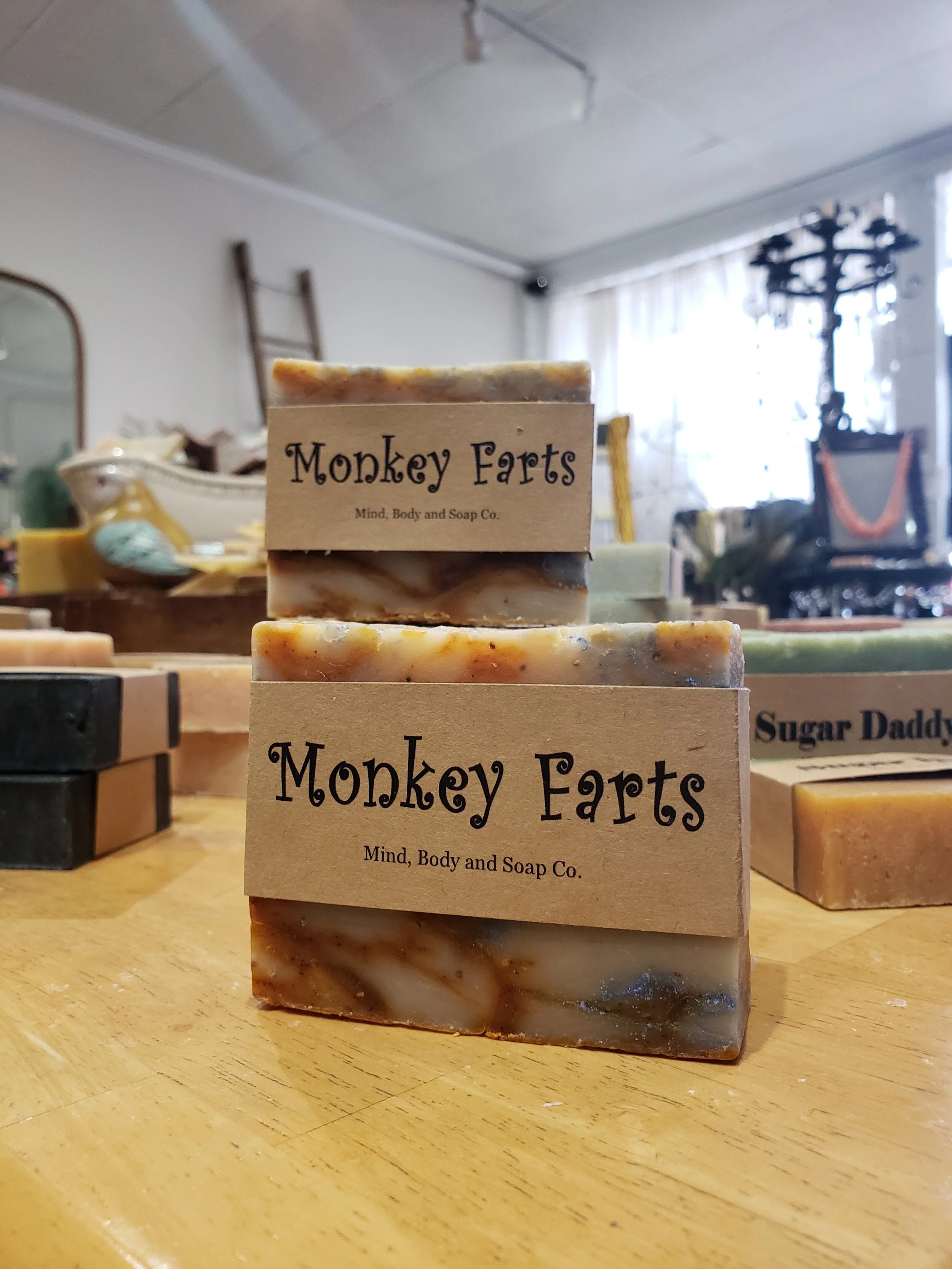 A photo of a rectangular block of soap with a tan label wrapped around it. The soap is a creamy color with a smooth surface and has a simple design.