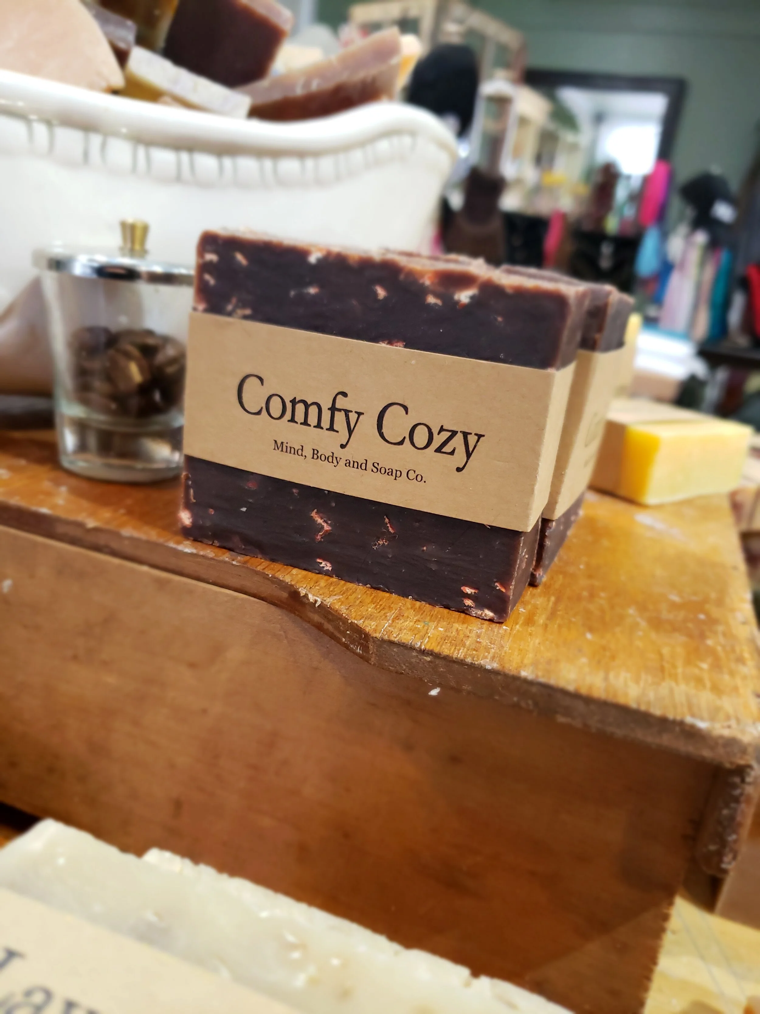 A photo of a rectangular block of soap with a tan label wrapped around it. The soap is a creamy color with a smooth surface and has a simple design.