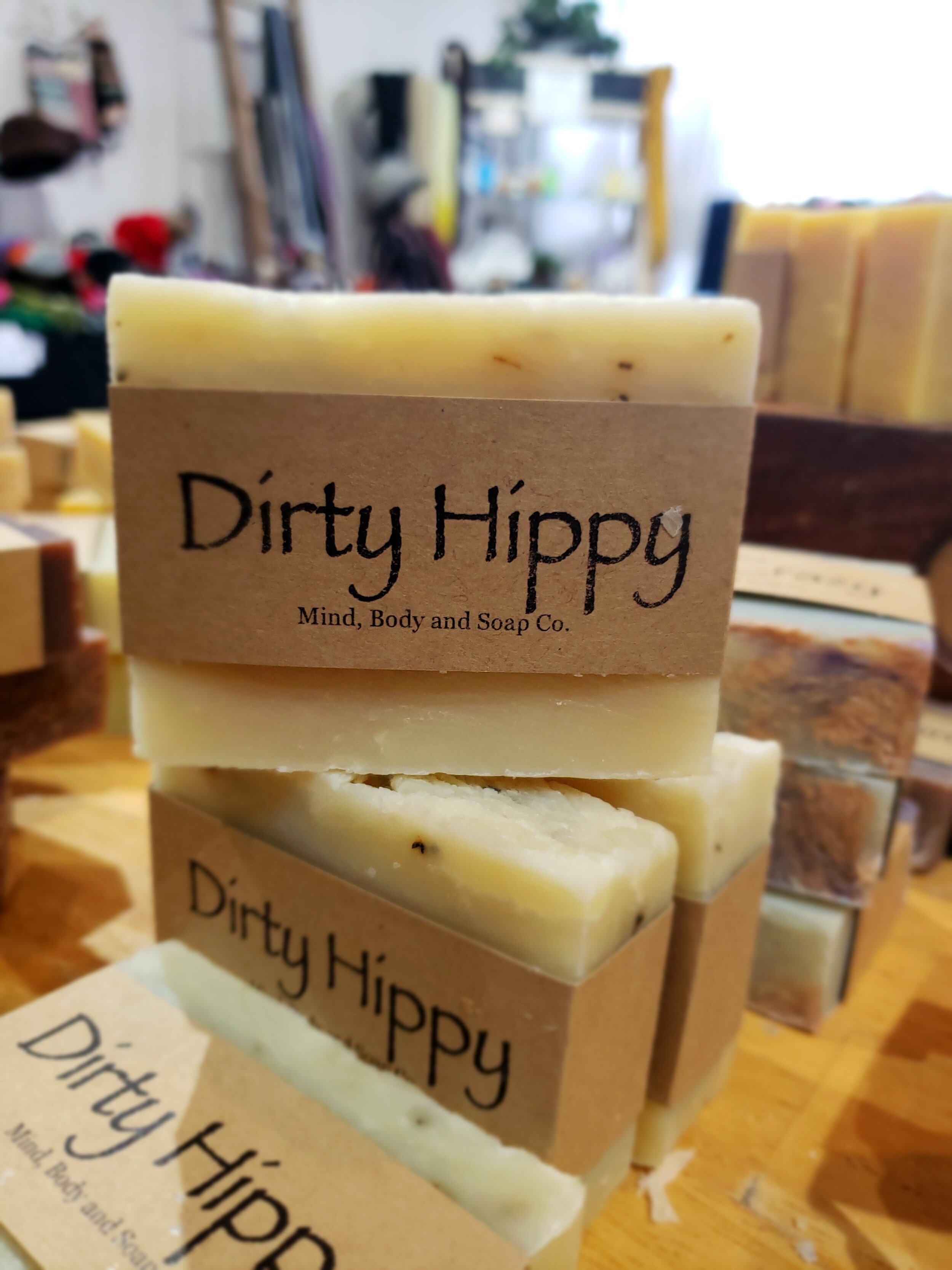 A photo of a rectangular block of soap with a tan label wrapped around it. The soap is a creamy color with a smooth surface and has a simple design.