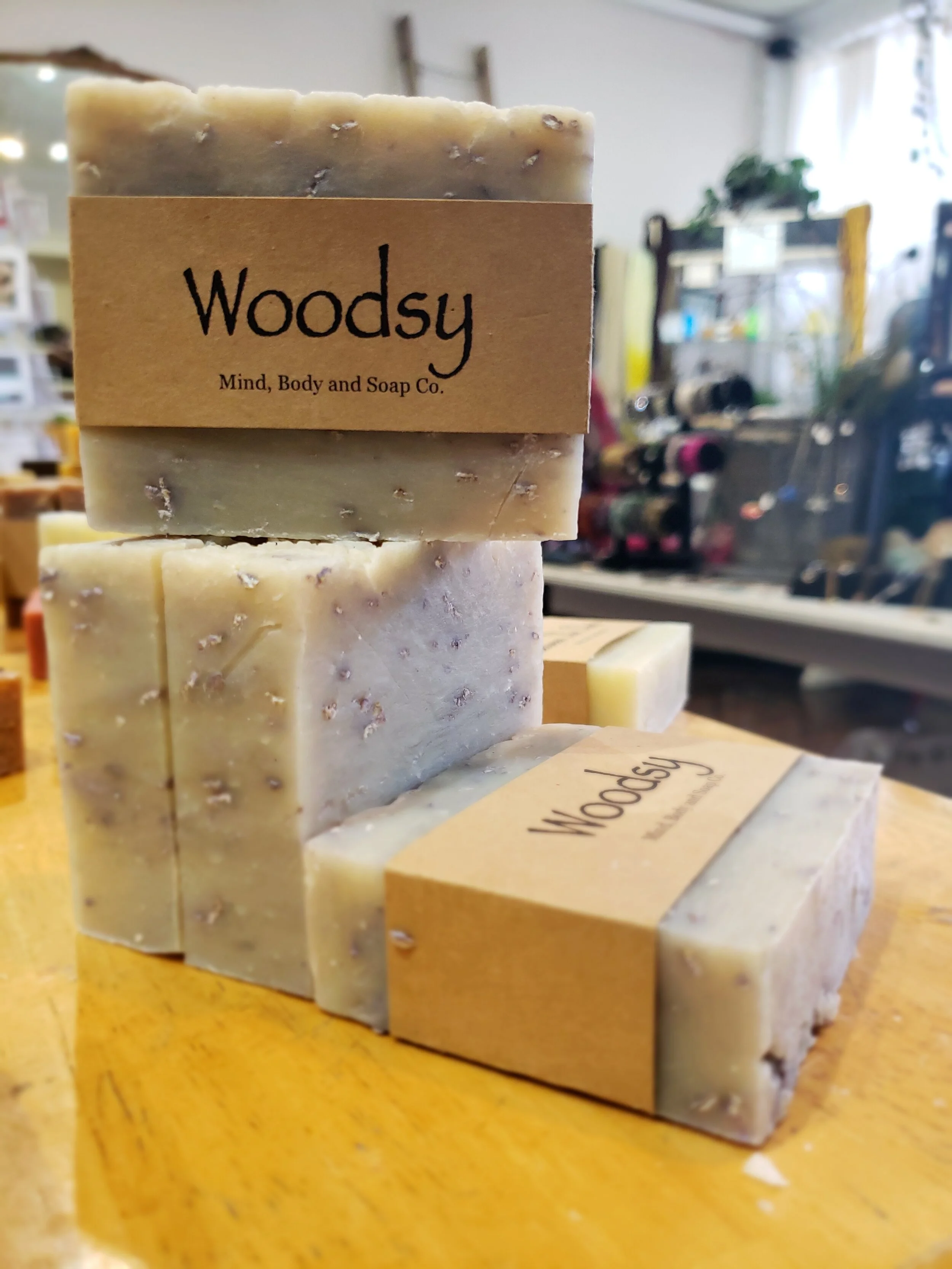 A photo of a rectangular block of soap with a tan label wrapped around it. The soap is a creamy color with a smooth surface and has a simple design.