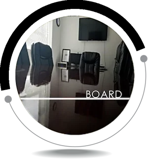 Small conference room with a wall-mounted TV, leather office chairs, and the word “BOARD” overlaid