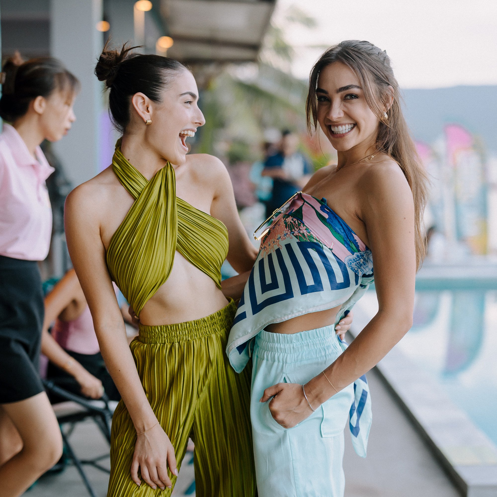 2 women at a beach restaurant with a pool