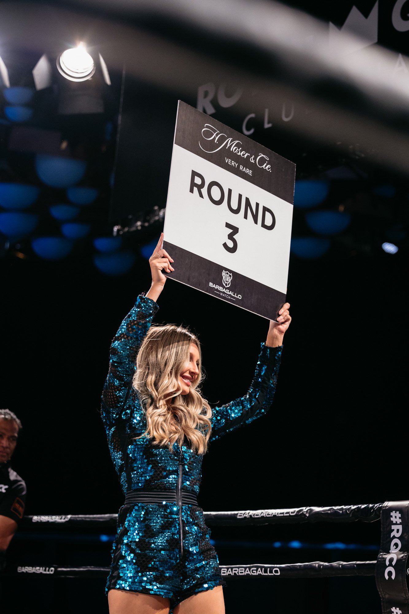 a ring girl holding a round sign