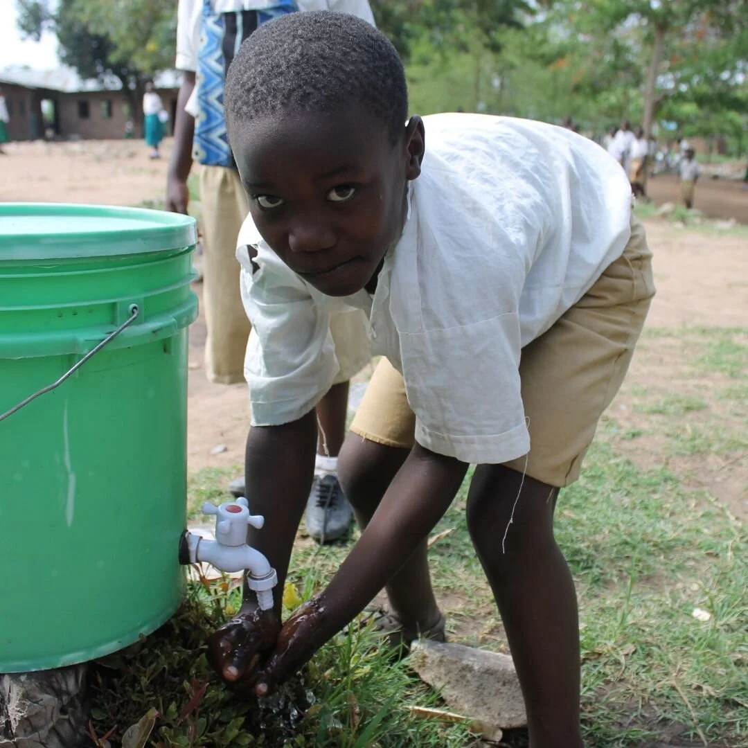 Child washing hands through a community climate resilience and environmental health initiative in Tanzania