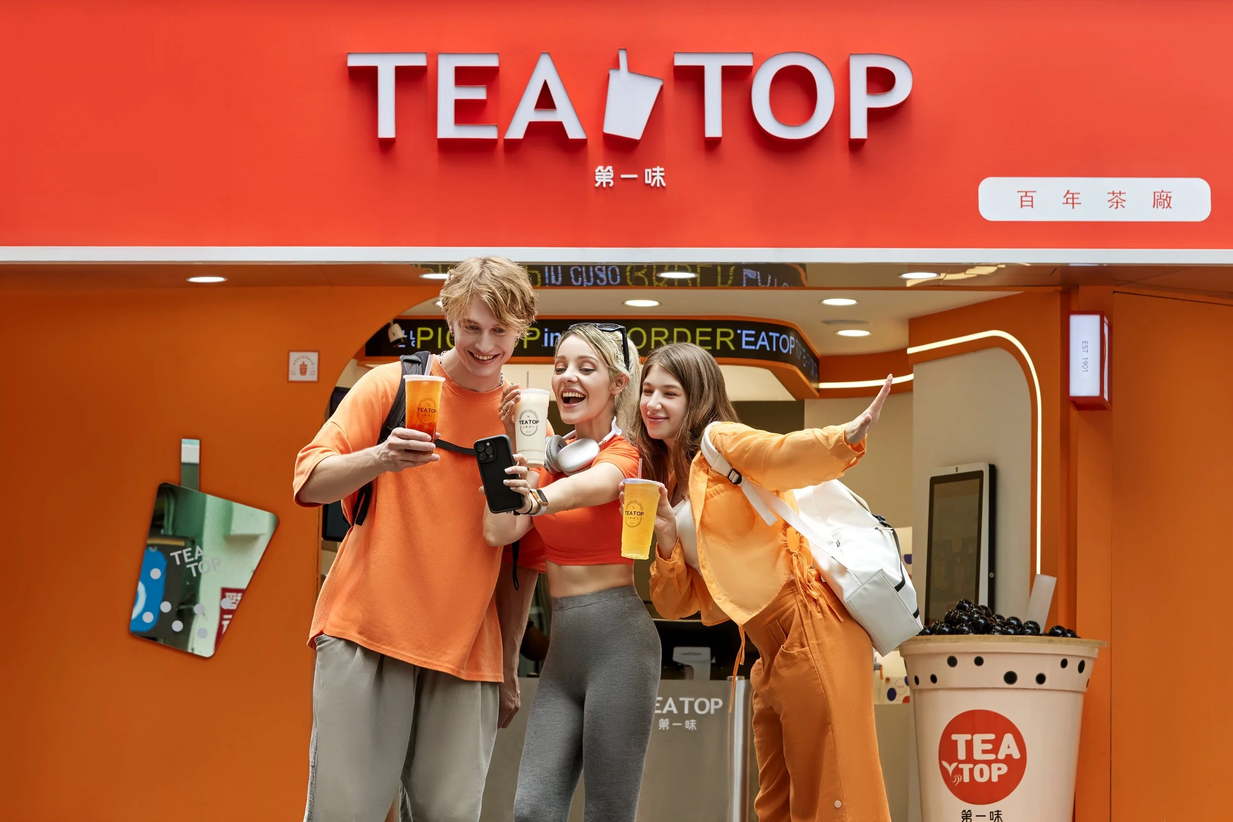 Friends sharing a moment outside a TEA TOP store in Taiwan — brand campaign photography.