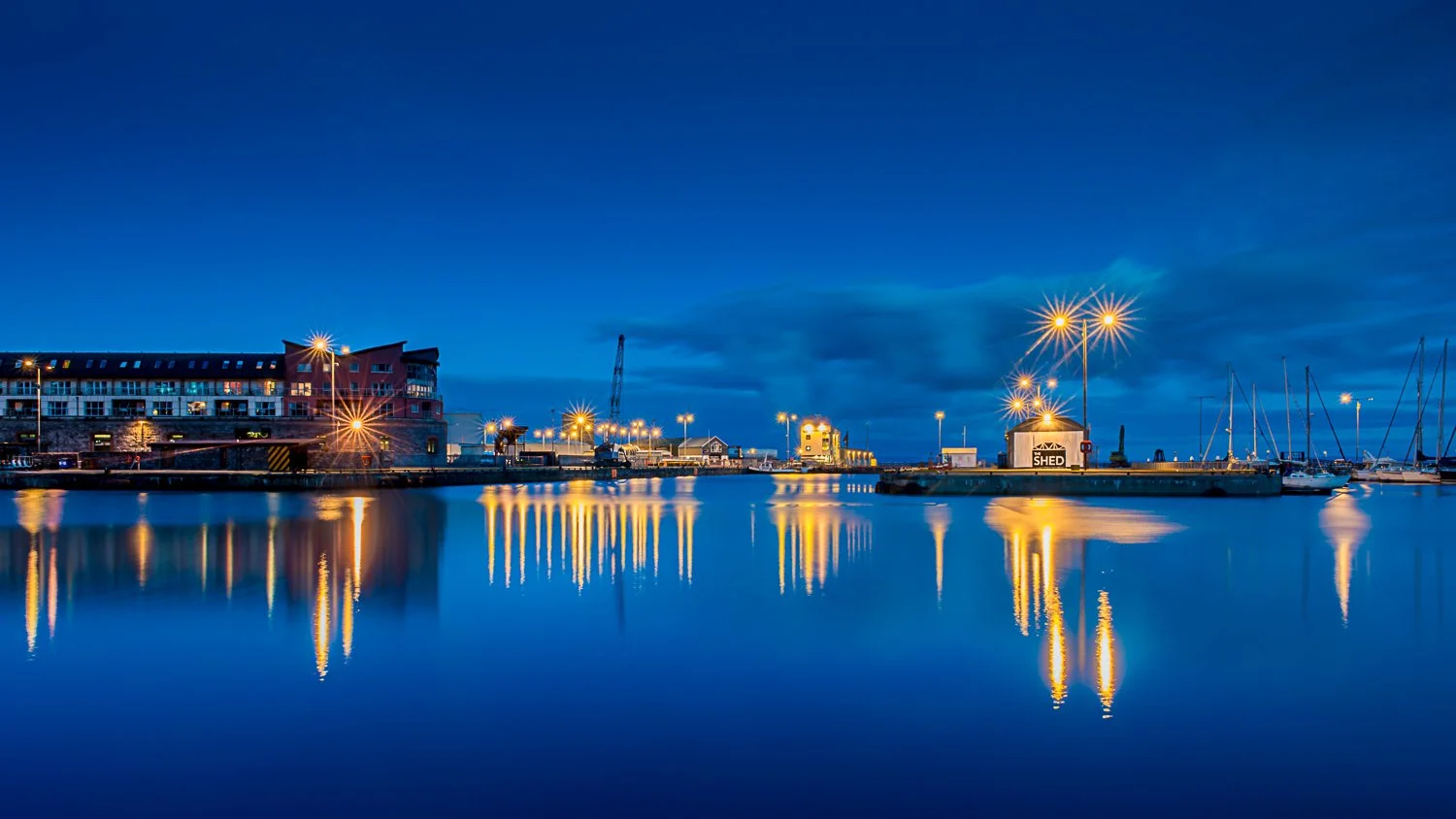 Galway Docks — still water and reflected lights at blue hour