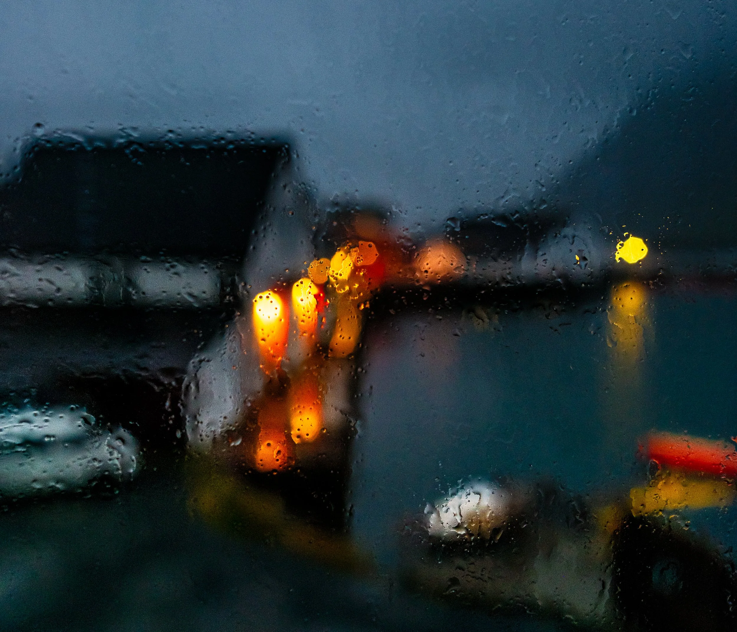 Rain drops on glass with blurred lights beyond the window in Norway