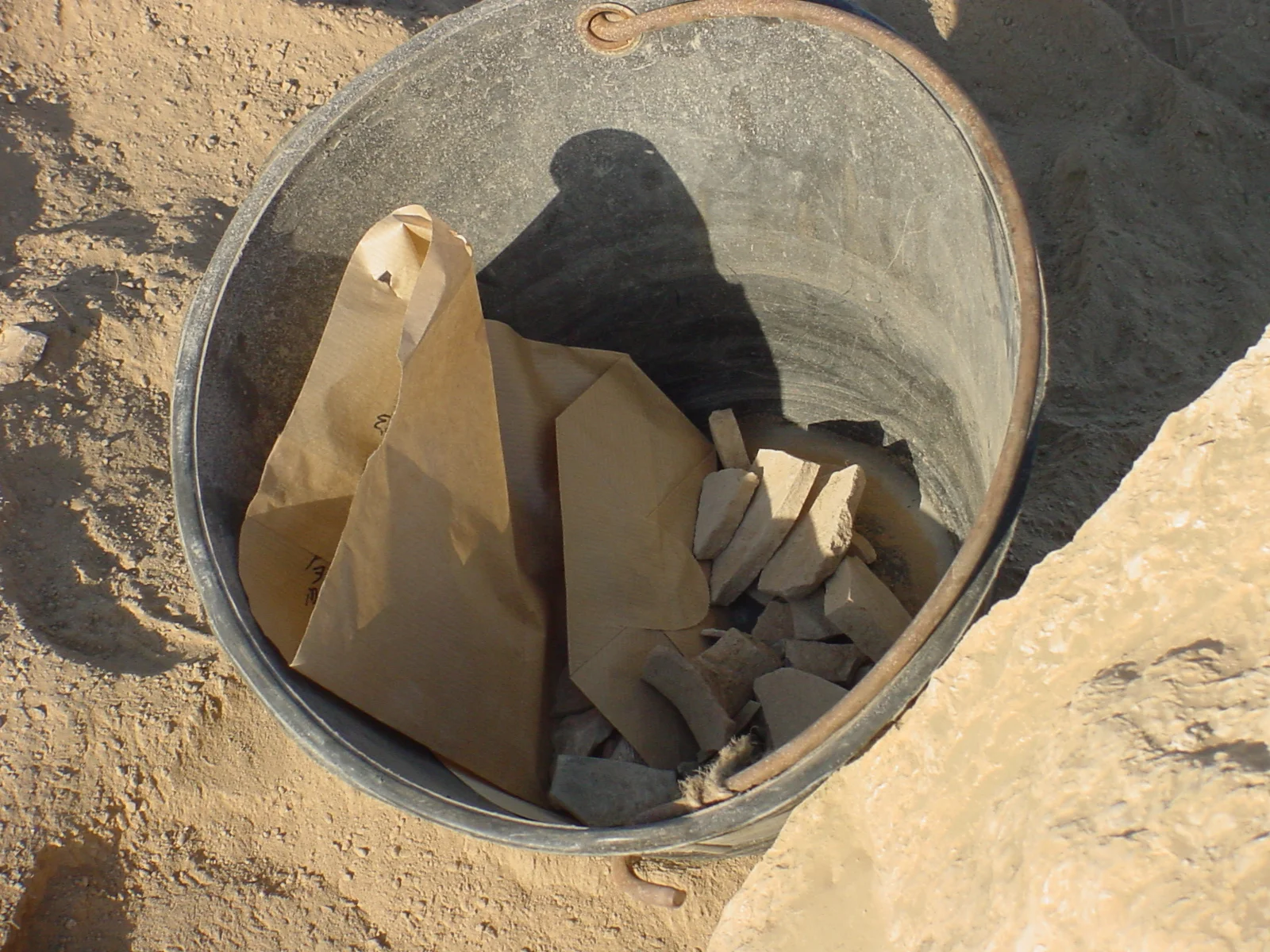   Remaining sherds are removed from the screen and placed in a plastic pail that is tagged with a specific number at the foot of the sift. This pail number is from that point on associated with the sherds placed in it.  