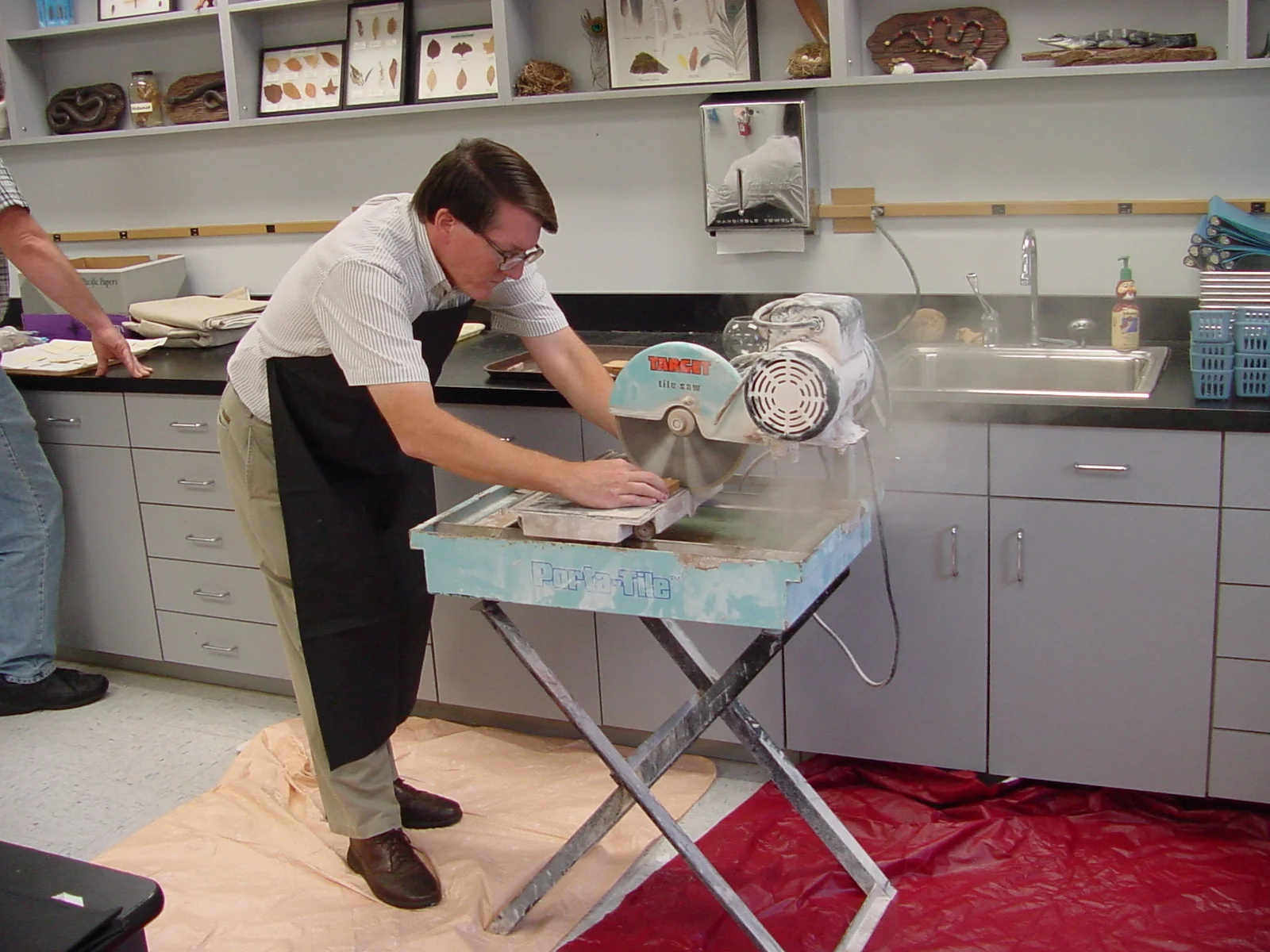   Registered pottery must be cut for two reasons: (1) to examine better the interior of the cross section of the sherds and (2) to create a flat surface so that the sherd can be traced when drawn. A saw with a diamond blade is used to make a clean cu