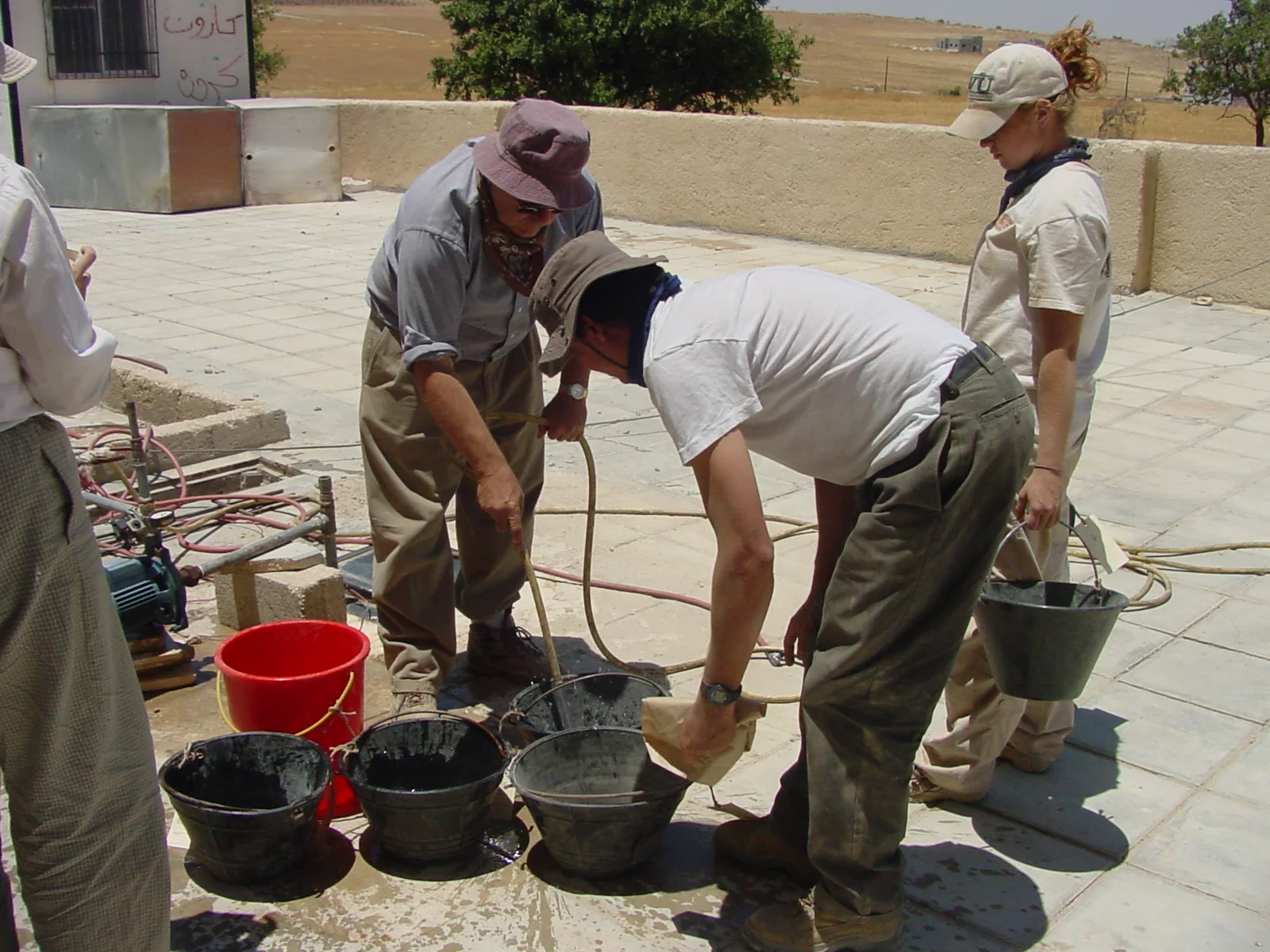  The tagged and numbered pails containing the morning's pottery finds are brought back to camp around noon when the workday at the site ends and camp work begins. Upon arrival at camp, workers from the sites squares fill each pail with water to allow