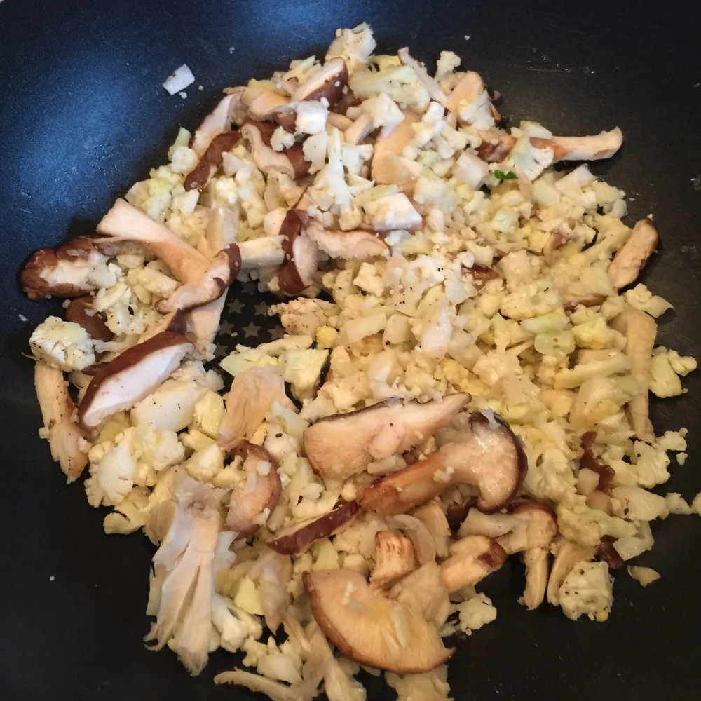Start with finely chopped cauliflower and chopped mushrooms in a bit of butter and sesame oil. Sauté until cooked and soft.