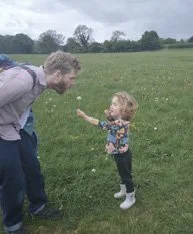 A child showing a wildflower to an adult on the Wild Walk