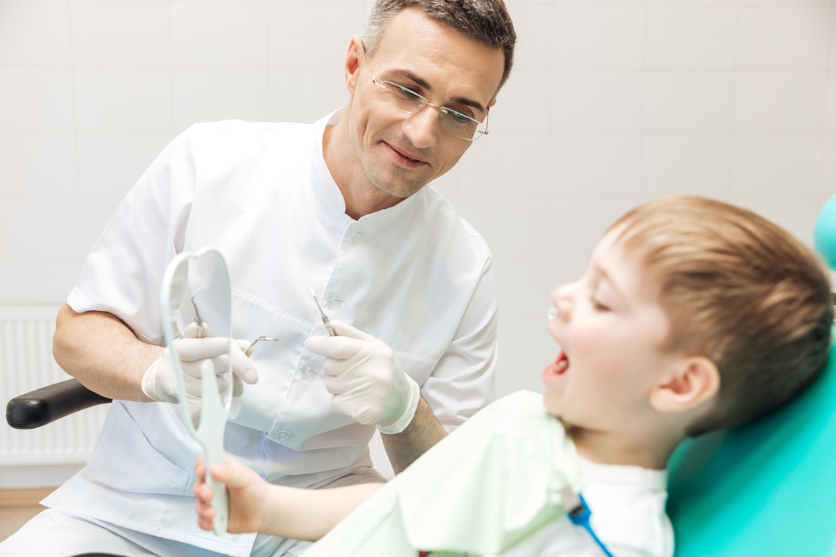 Little boy looking at the mirror during oral inspection