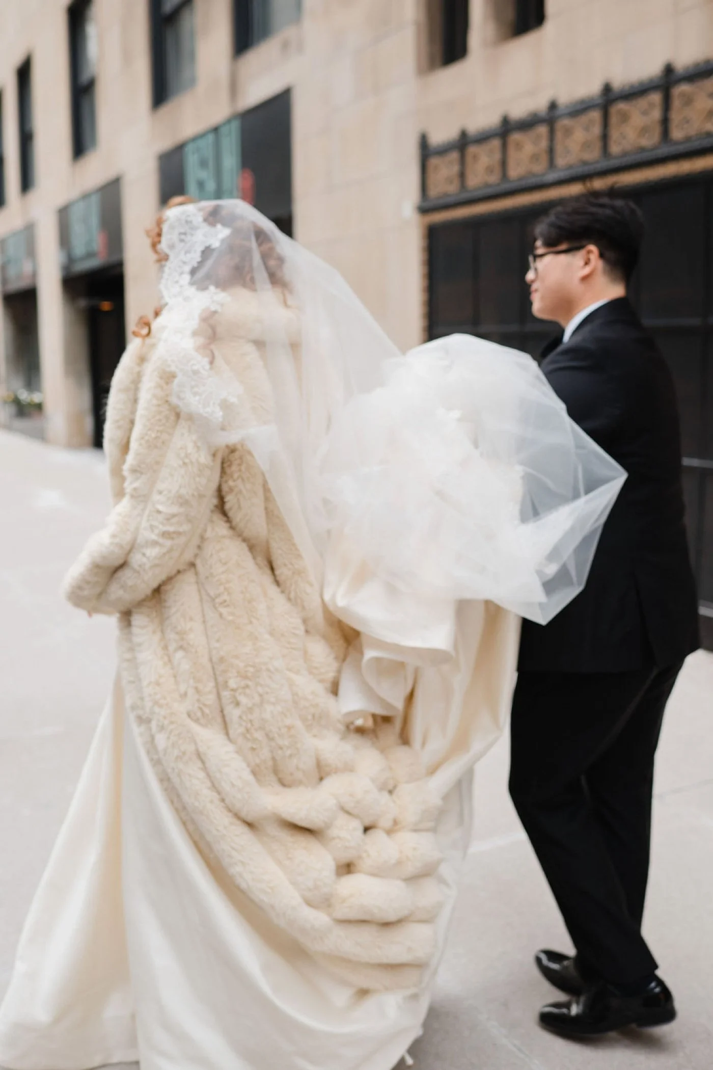 Bride wearing an ivory fur coat for her Chicago winter wedding