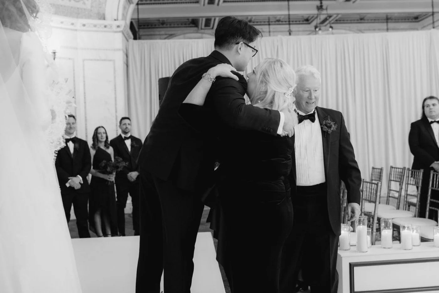 Parents of bride hugging groom after walking her down the aisle