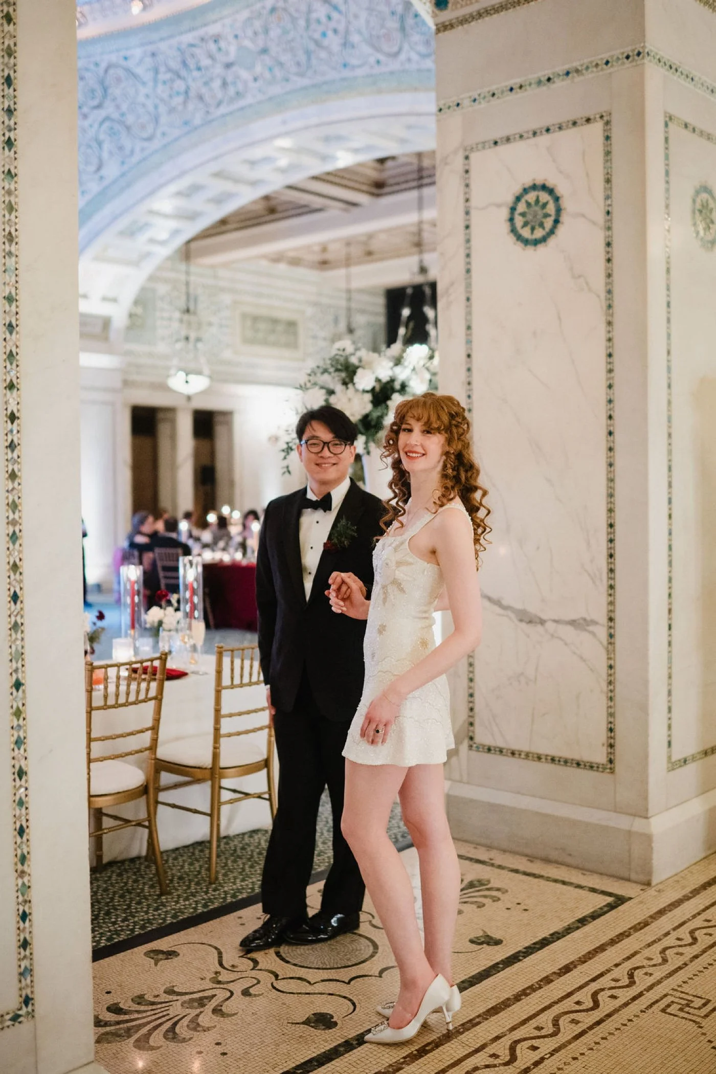 Bride wearing a beaded sun ivory mini dress for her wedding reception