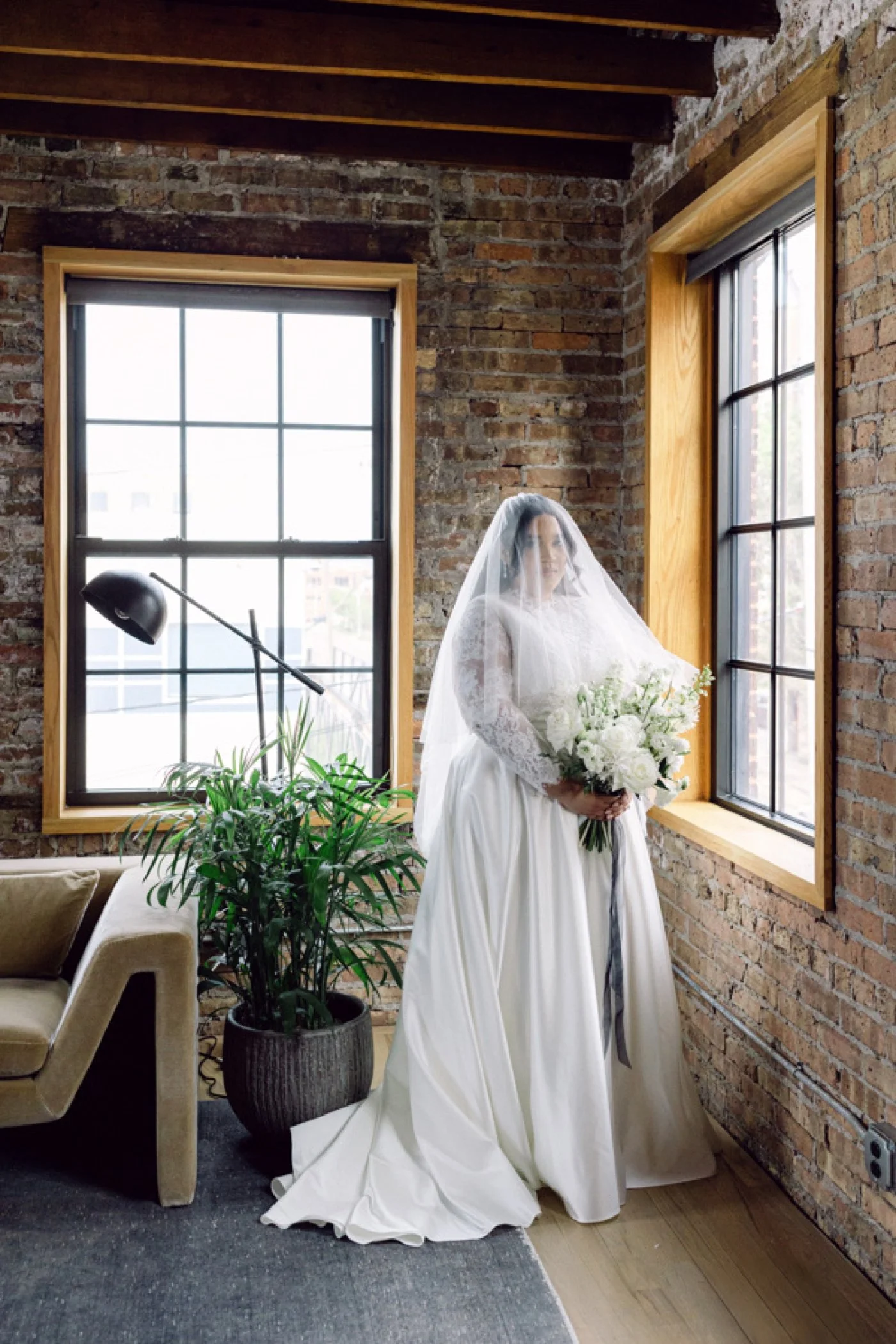 Chicago bride wearing a long-sleeved gown with lace sleeves and a veil over her face