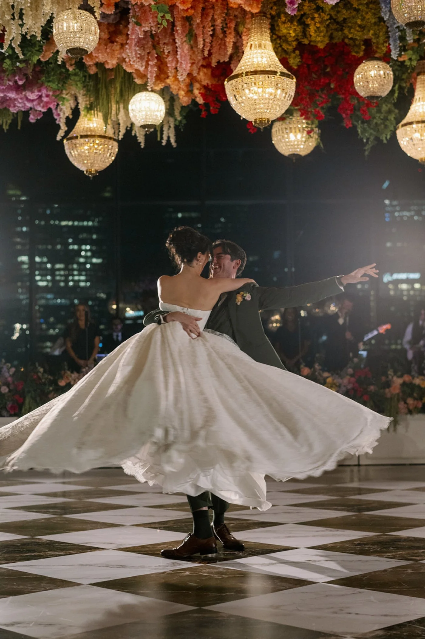 Bride and groom dancing underneath crystal chandeliers and ceiling florals at their Chicago wedding