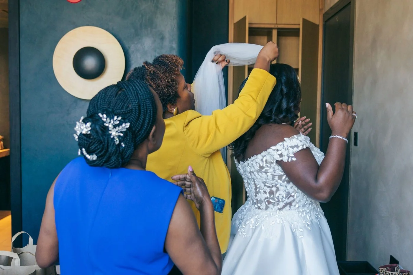 Wedding planner helping bride with veil