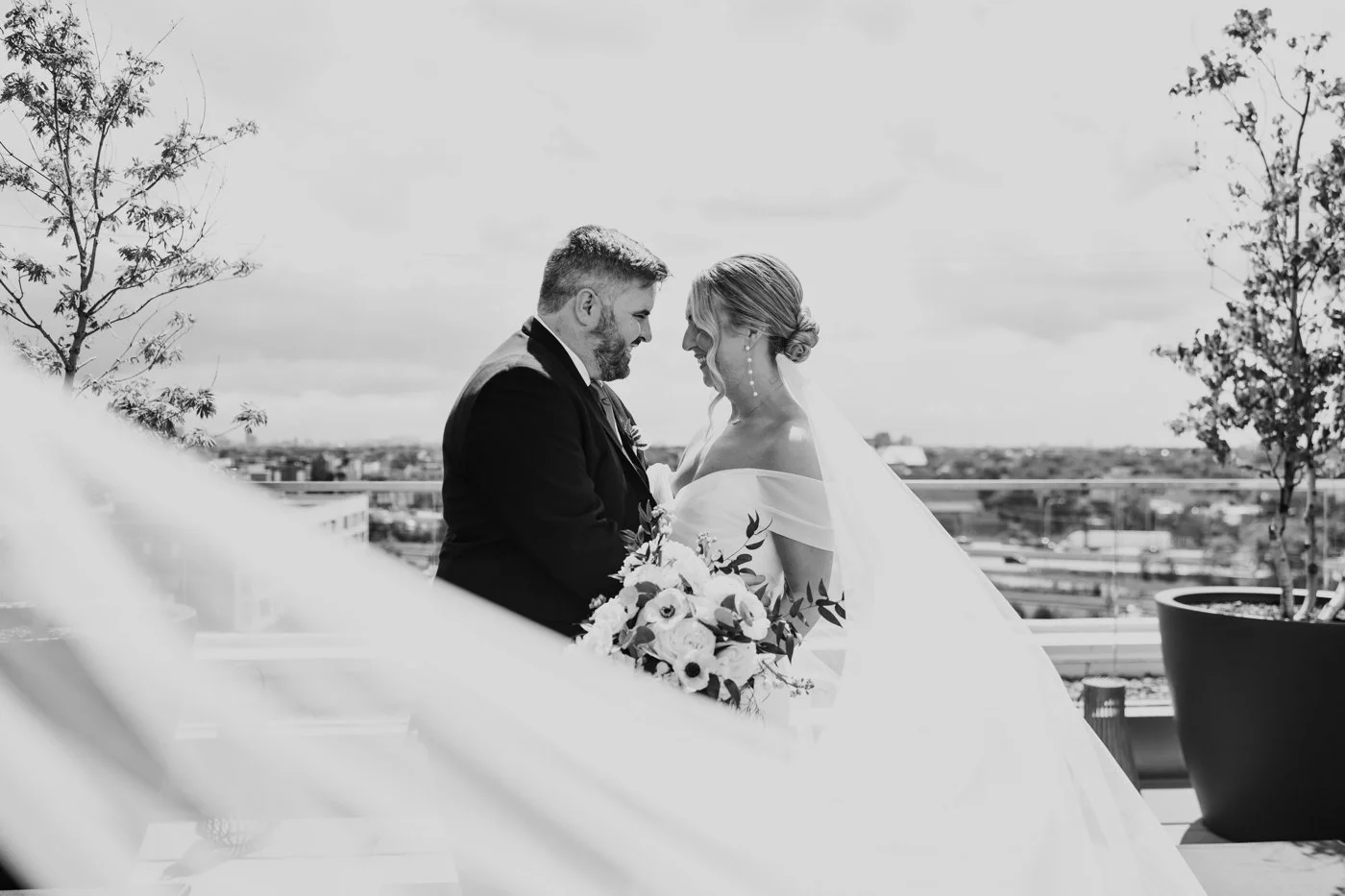 Black and white bridal portrait with veil blowing in the wind