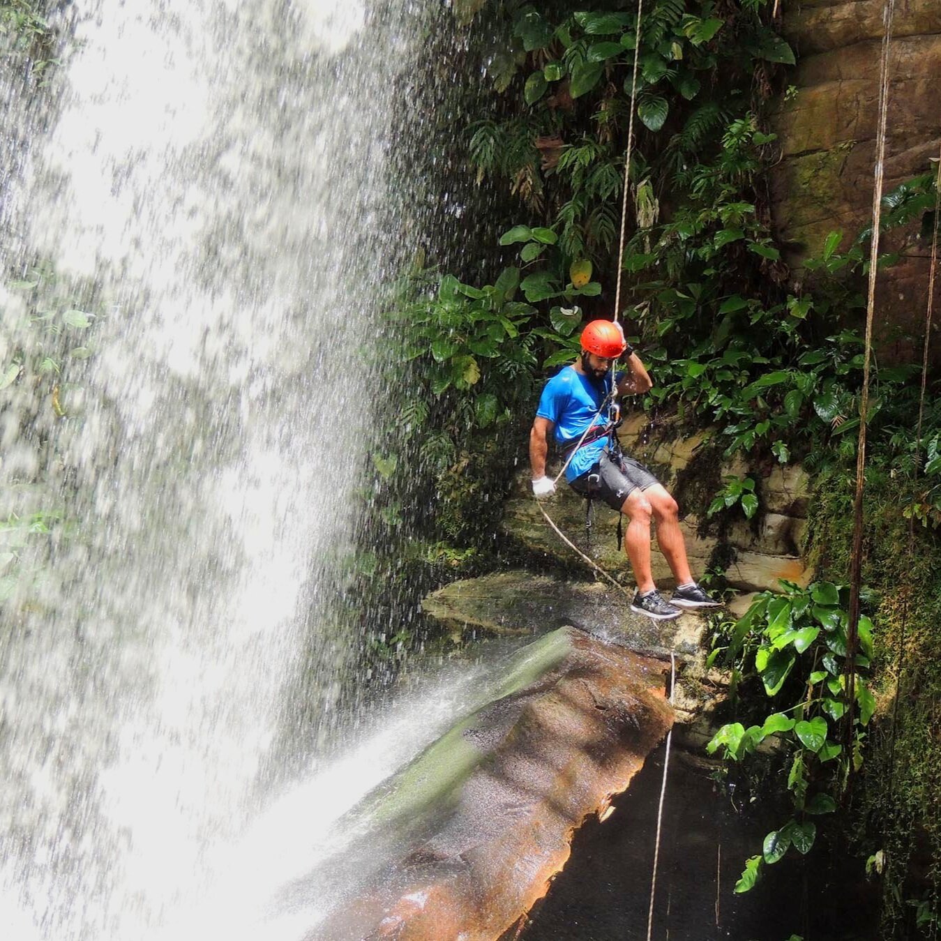 Man Rappelling down Waterfall