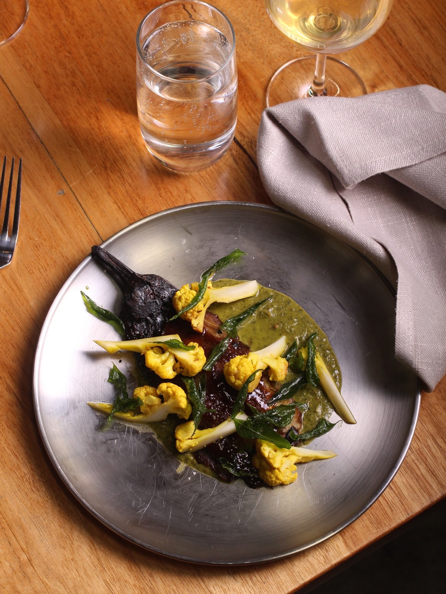 Woodfired glazed eggplant, cauliflower pickle, coriander chutney, curry leaves. 

Vegan, gluten free and nut free, and so damn delicious!