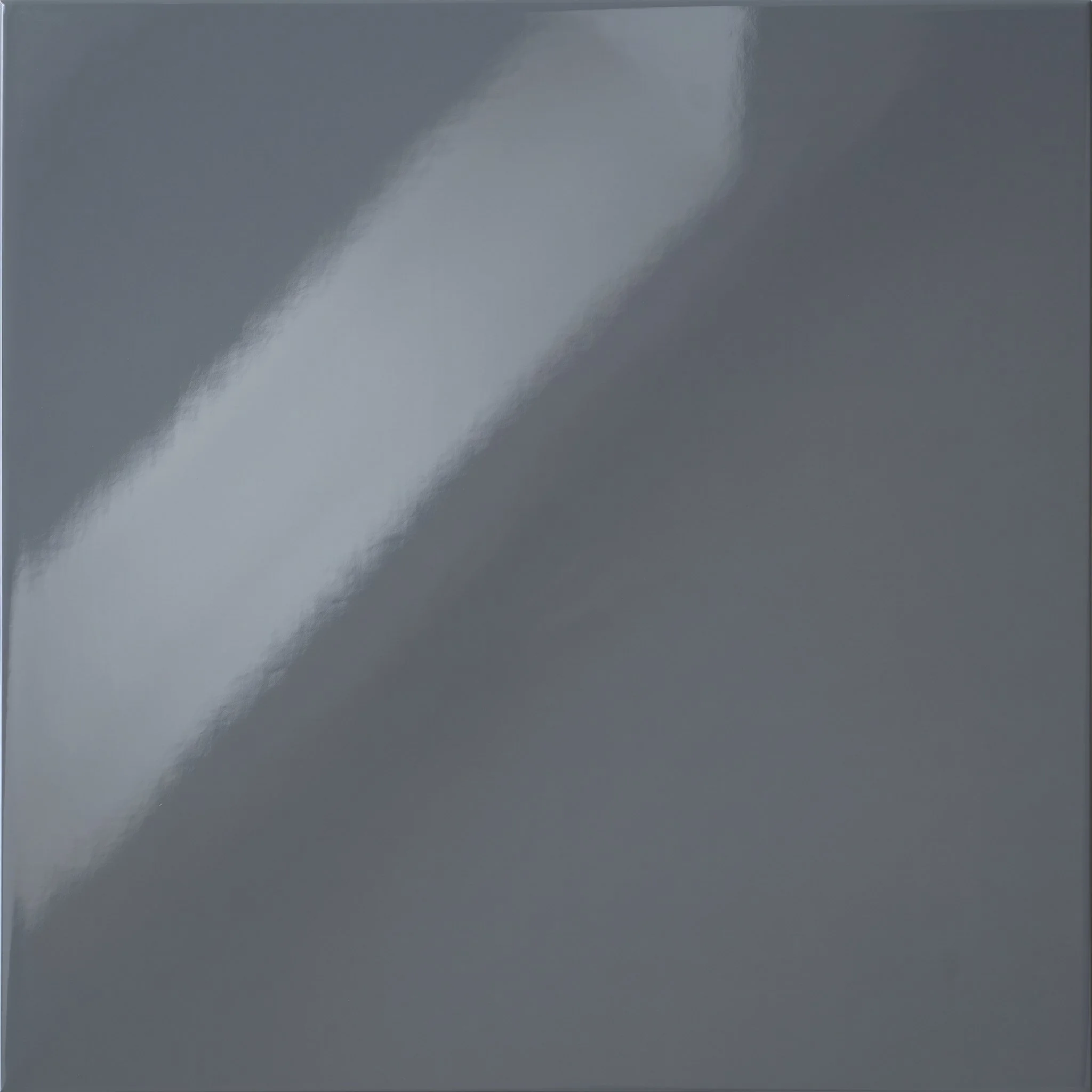 Close-up of a dark gray or black computer or electronic device with a shiny, reflective surface.