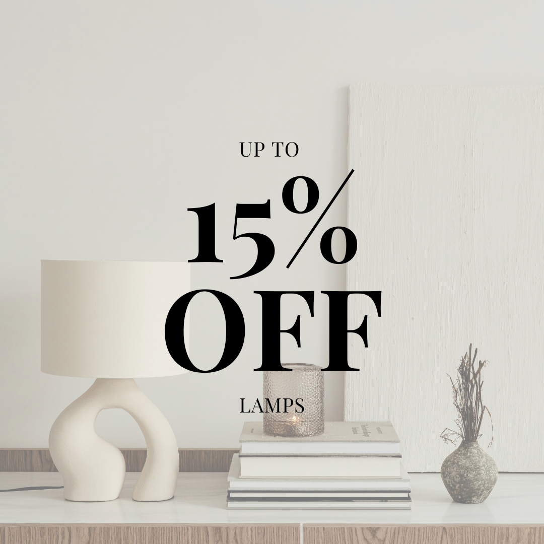 Advertisement for up to 15% off on lamps featuring a modern white lamp, glass candle holder, and decorative vases on a white and wooden surface.