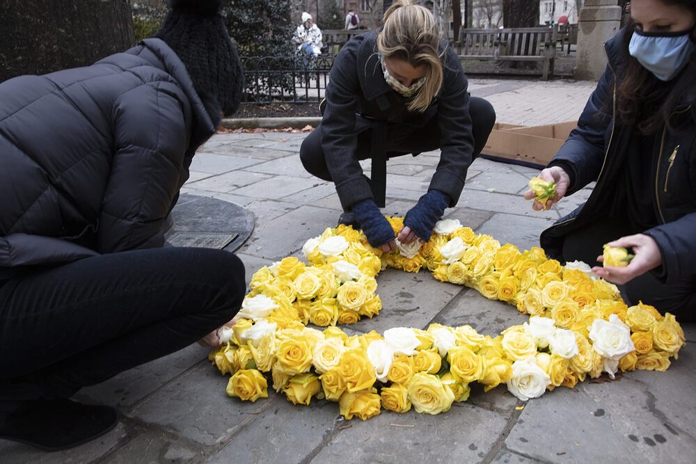  Addin finishing touches to floral heart laid in Rittenhouse Square for the Floral Heart Project, a Covid Memorial, March 2021.  Photo credit: Wendy Concannon Photography 