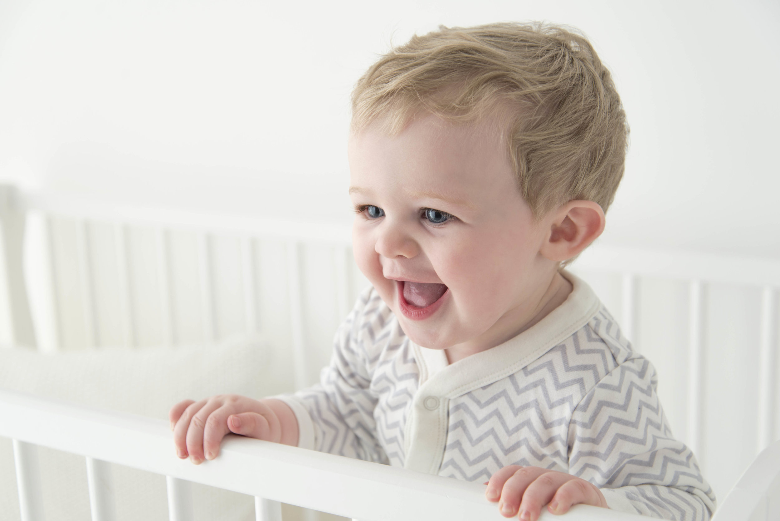 baby in cot laughing