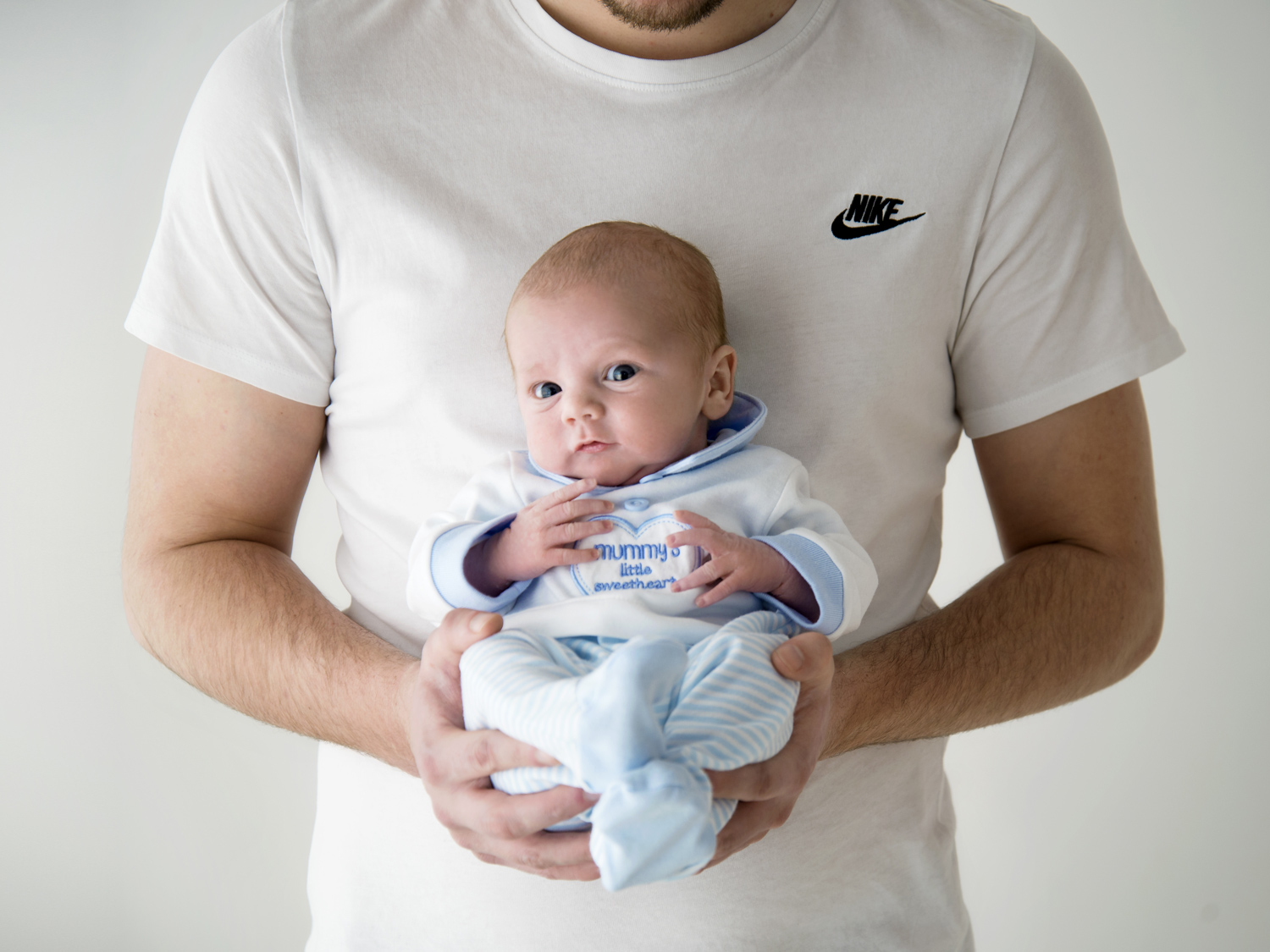 newborn baby held by father