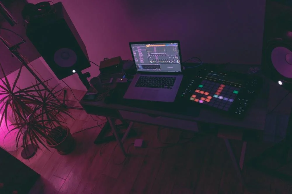 Alarke's Studio Setup With Plant, Speakers, Audio Interface, Controller, and Macbook.jpg