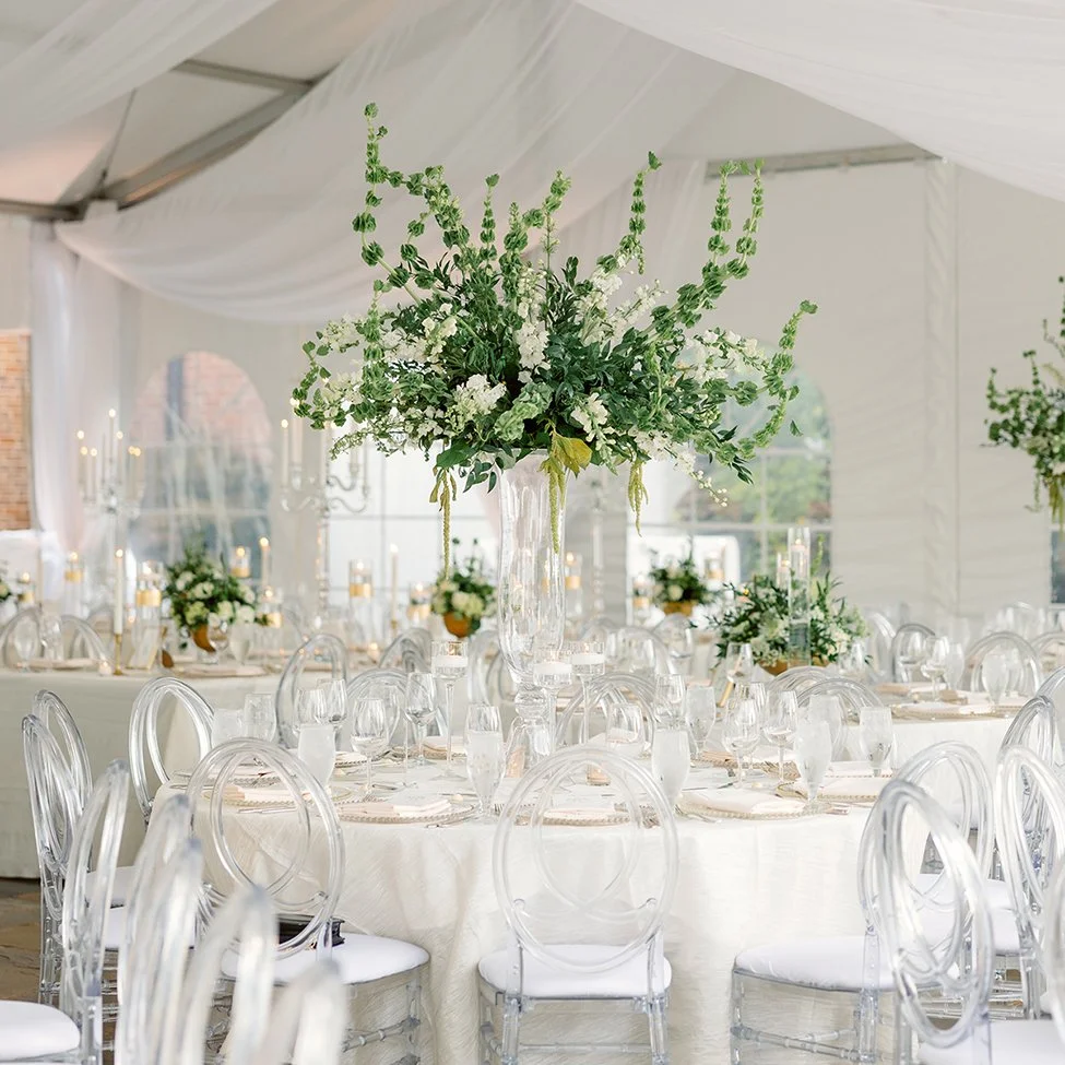 Wedding reception tent in St. Louis featuring green and white flowers in a tall centerpiece.