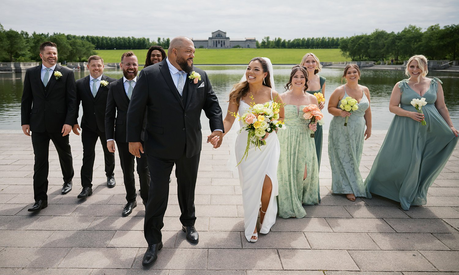 Wedding party walking in front of the St. Louis Art Museum with wedding bouquets designed by Belli Fiori.