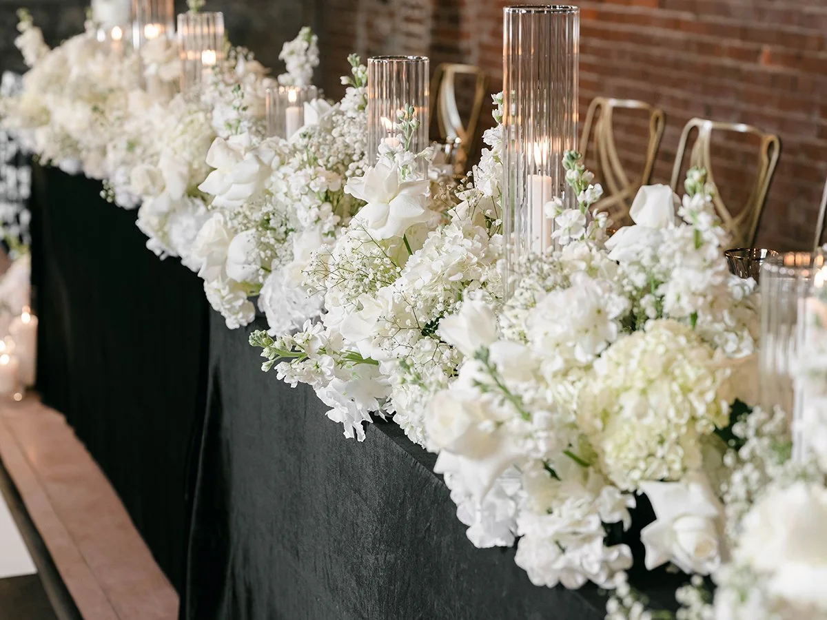 All white floral wedding head table centerpiece by Belli Fiori at the Gatsby Events Venue in St. Louis.