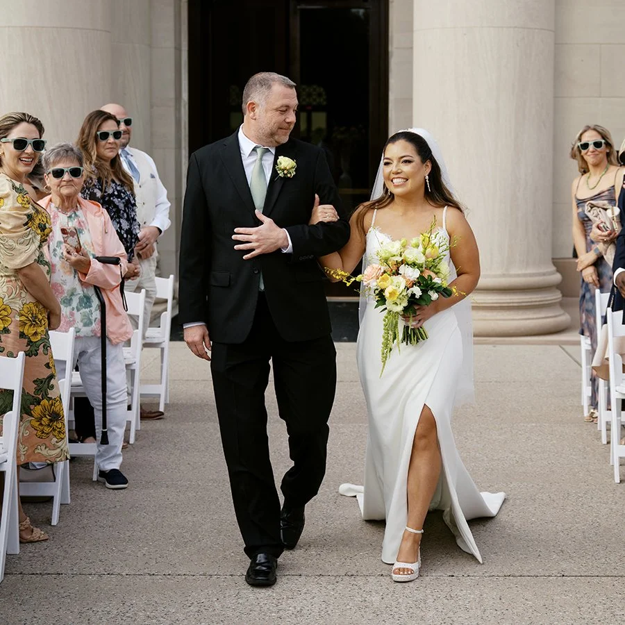 Bride and dad walking down the wedding ceremony aisle at the St. Louis Art Museum designed by Belli Fiori.