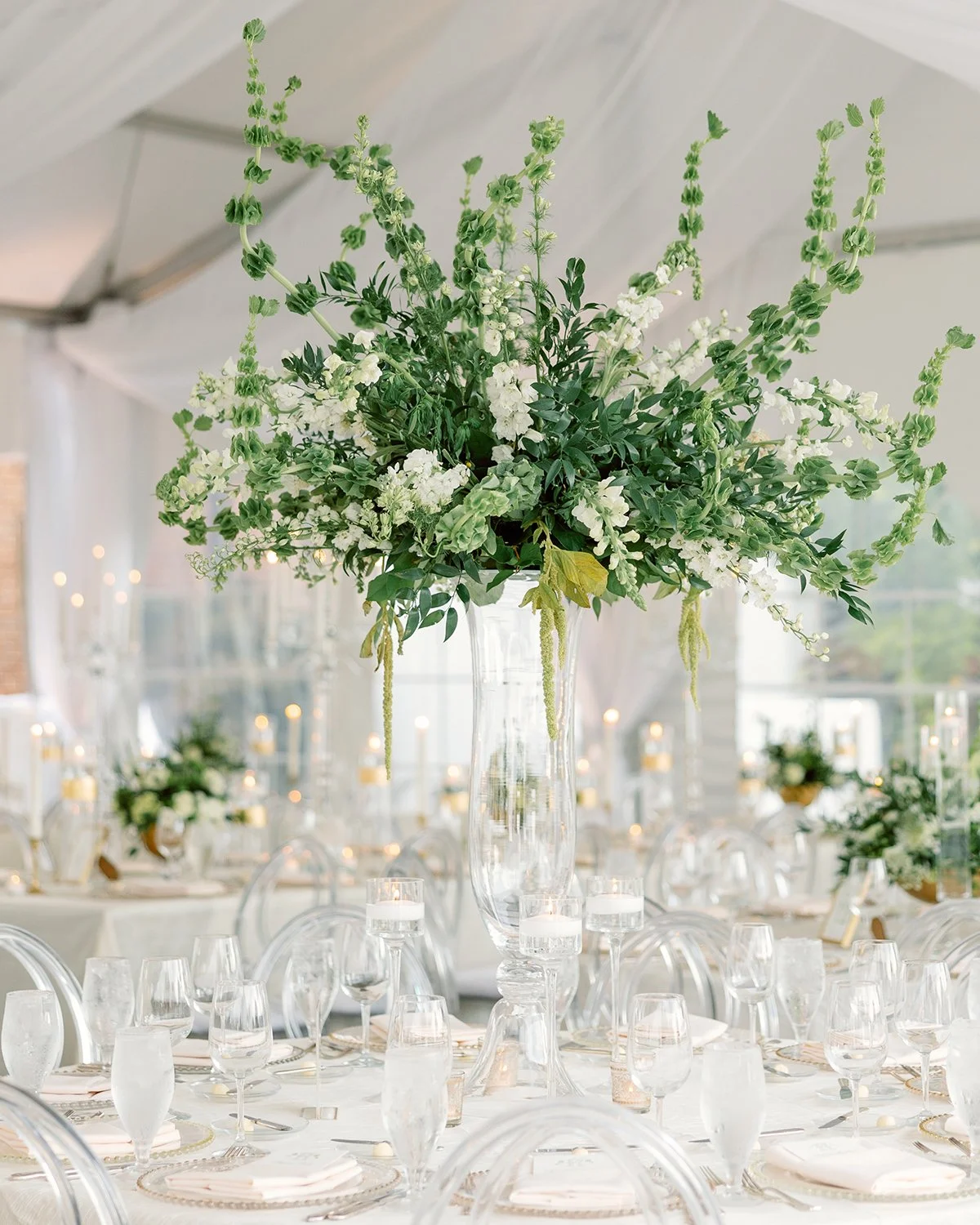 A crisp and fresh look in all white and green...perfect for summer weddings.🤍💚🤍

Against the white backdrop of the tent, each centerpiece drew the eye and created an etherial look.

Photo+Video: @chosenphotographyphotos
Planning: @simchasevents
De