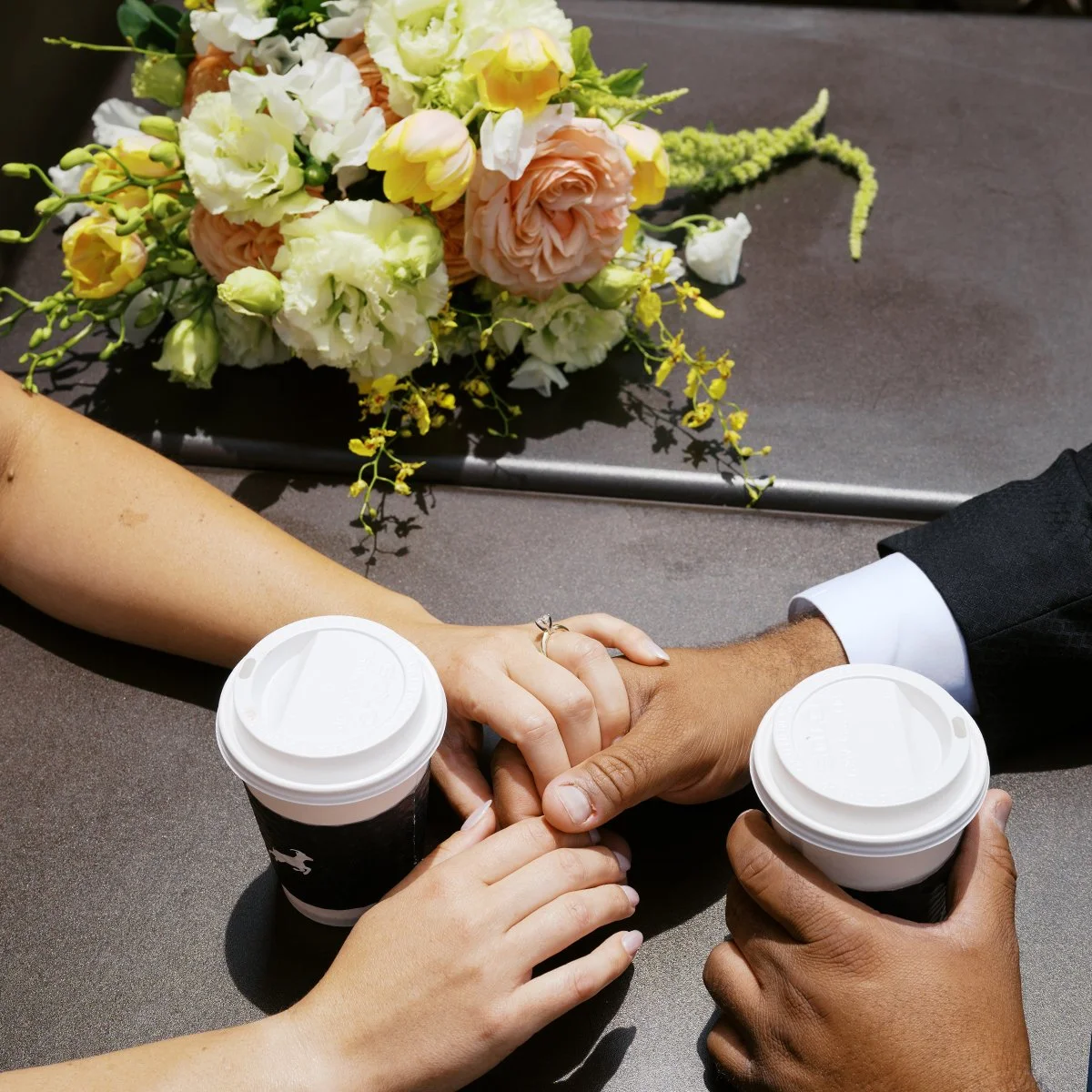 Bride and groom having coffee at their first date spot with flowers designed by Belli Fiori based in St. Louis.