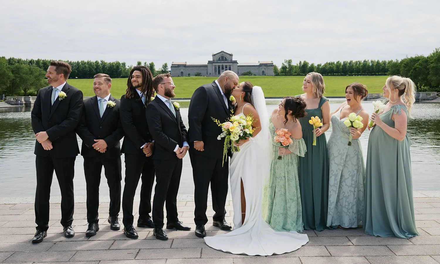 Wedding party walking in front of the St. Louis Art Museum with wedding bouquets designed by Belli Fiori.