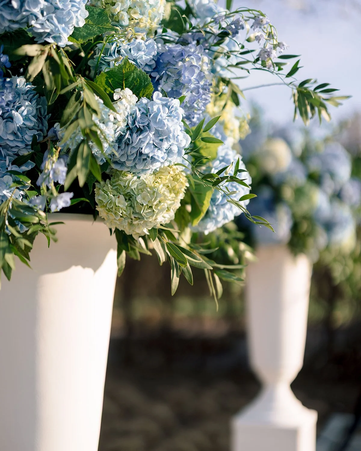 Blue and white wedding ceremony flowers at the Missouri Botanical Garden designed by Belli Fiori.
