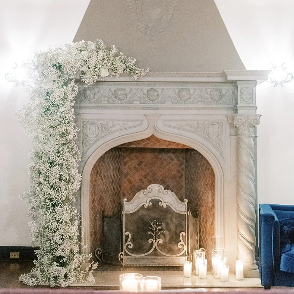 Baby's Breath wedding flowers in an asymmetric design climbing one side of the fireplace at The Coronado venue in St. Louis.