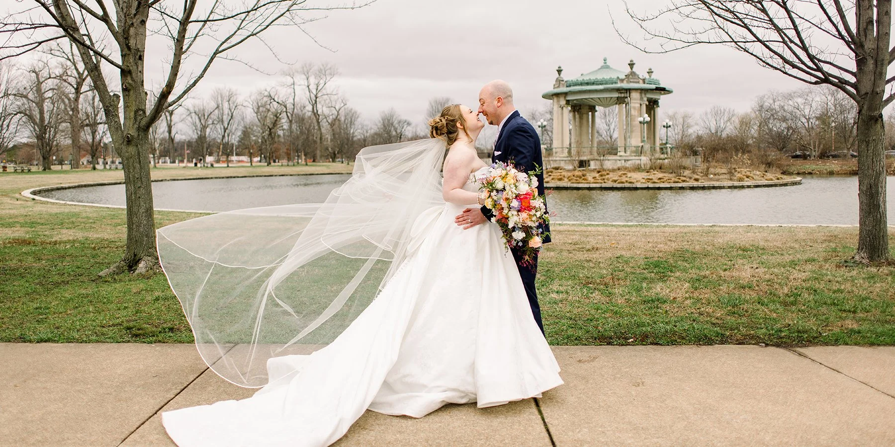 Bride and groom with a cascading floral bridal bouquet by Belli Fiori in St. Louis.