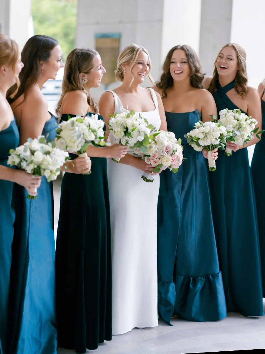 Bridesmaids in teal dresses holding blush and white rose bouquets in St. Louis.
