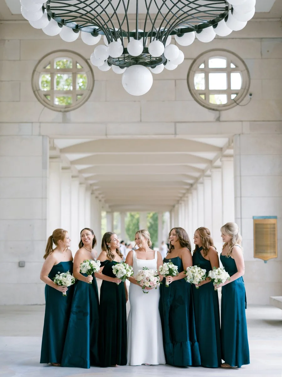Bridesmaids in teal dresses holding blush and white rose bouquets in St. Louis.